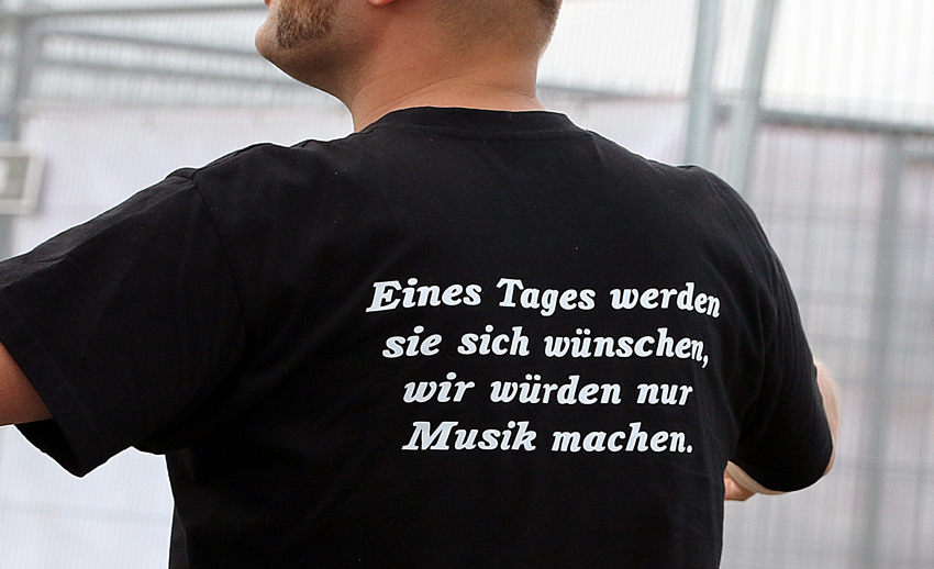 Mann mit einem T-Shirt, auf dem steht: "Eines Tages werden sie sich wünschen, wir würden nur Musik machen."