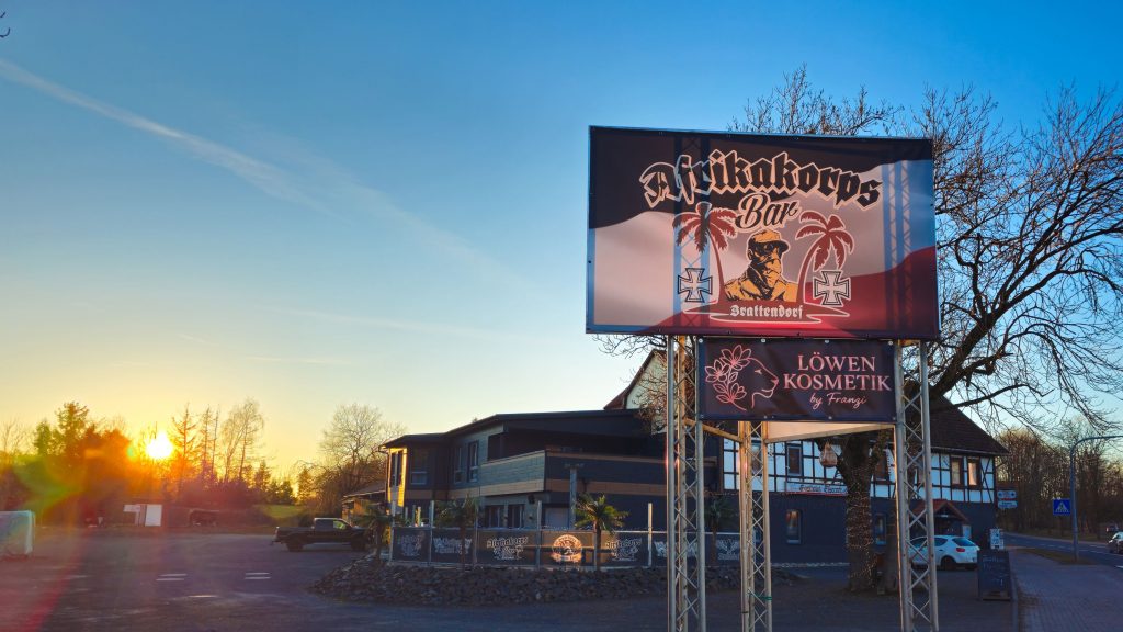 Das "Gasthaus Eiserner Löwe" in dem die meisten RechtsRock-Konzerte Thüringens stattfinden. Im Vordergrund sind Werbebanner für die "Akrikakorps-Bar" und für "Löwen Kosmetik by Franzi" zu sehen.